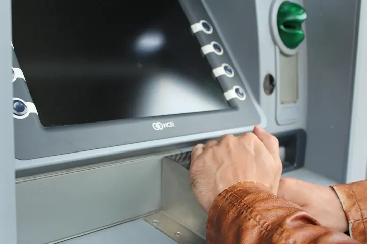 Mano usando un cajero automático